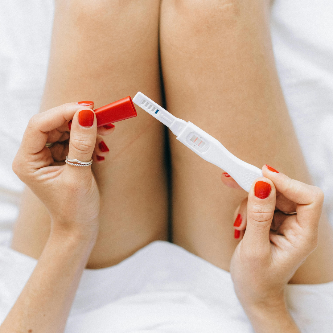 Woman holding pregnancy test.